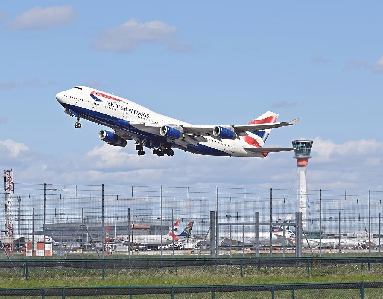 Avion de ligne décollant devant une tour