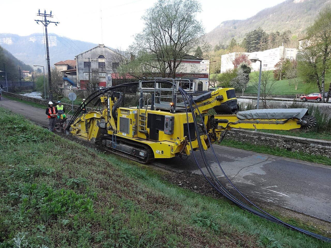Engin de chantier posant des câbles en zone rurale