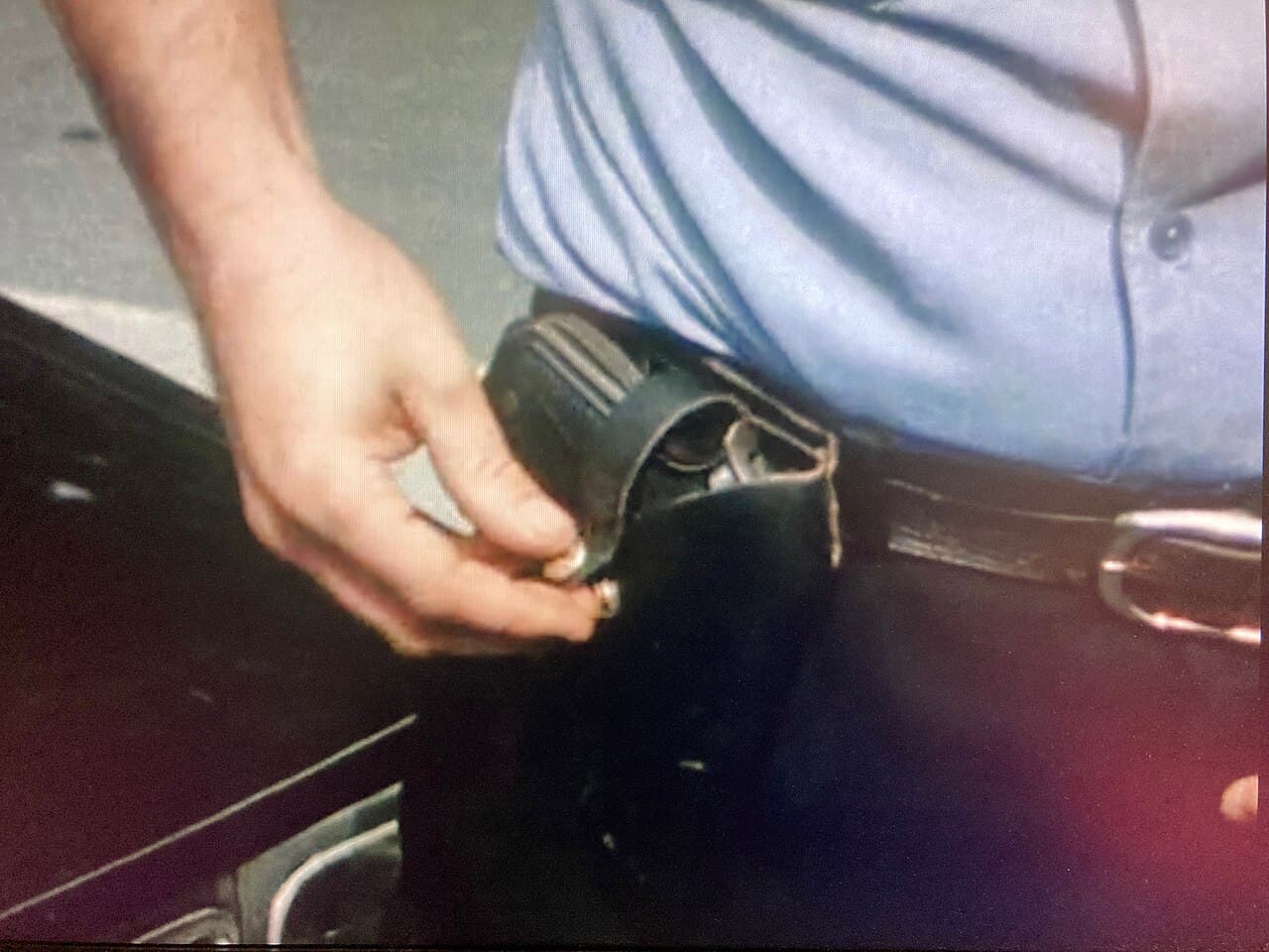 Main sur un étui d’arme à feu