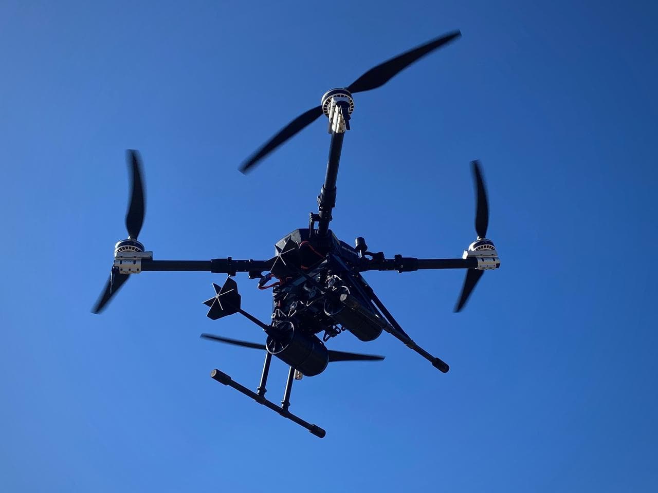 Drone quadricoptère en vol dans un ciel bleu