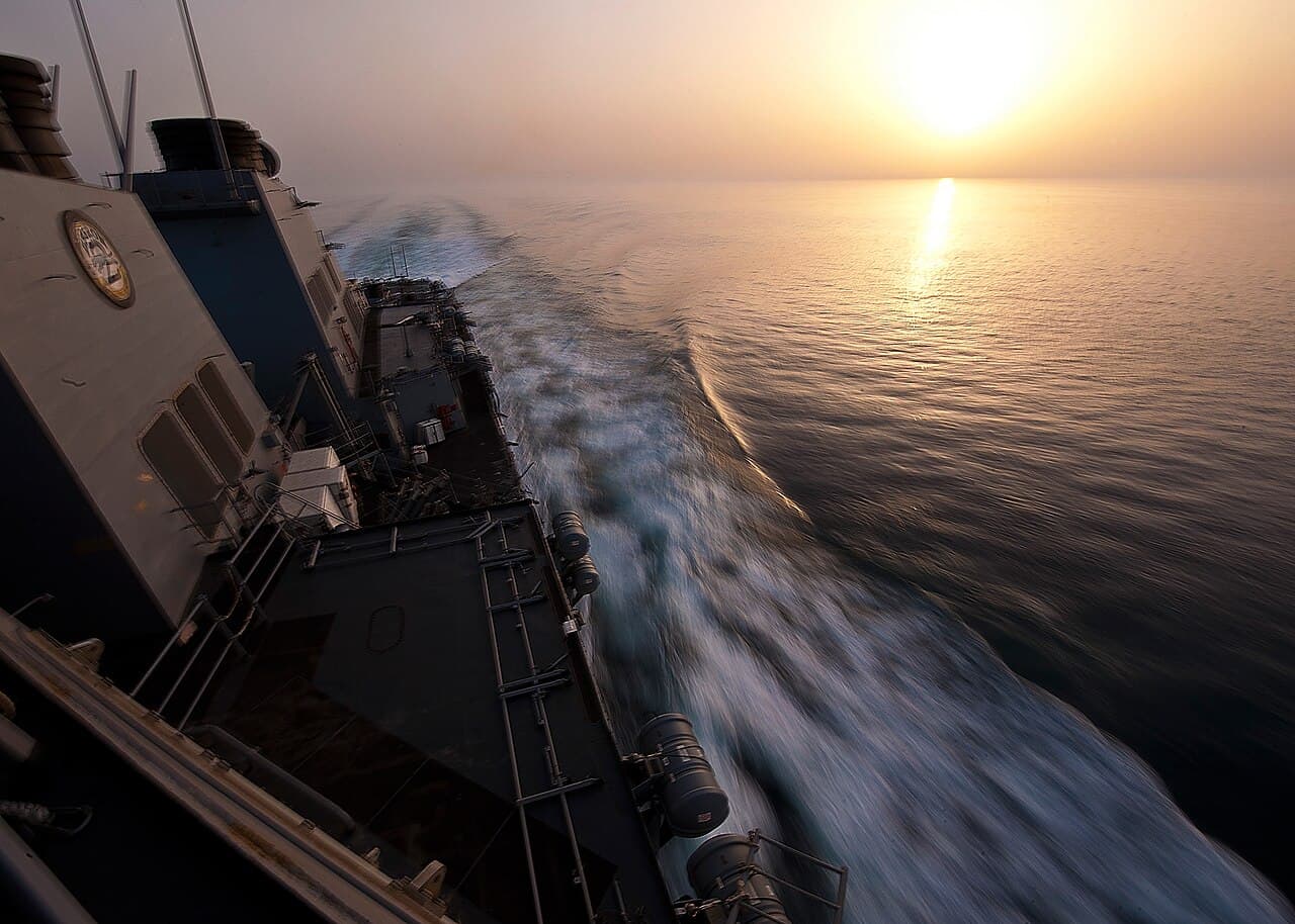 Navire militaire en mer au coucher du soleil