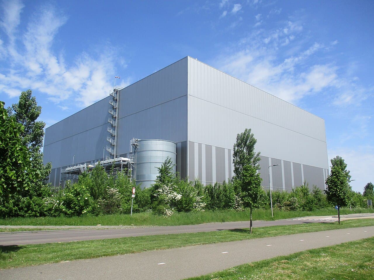 Grand bâtiment industriel au bord d'une piste cyclable
