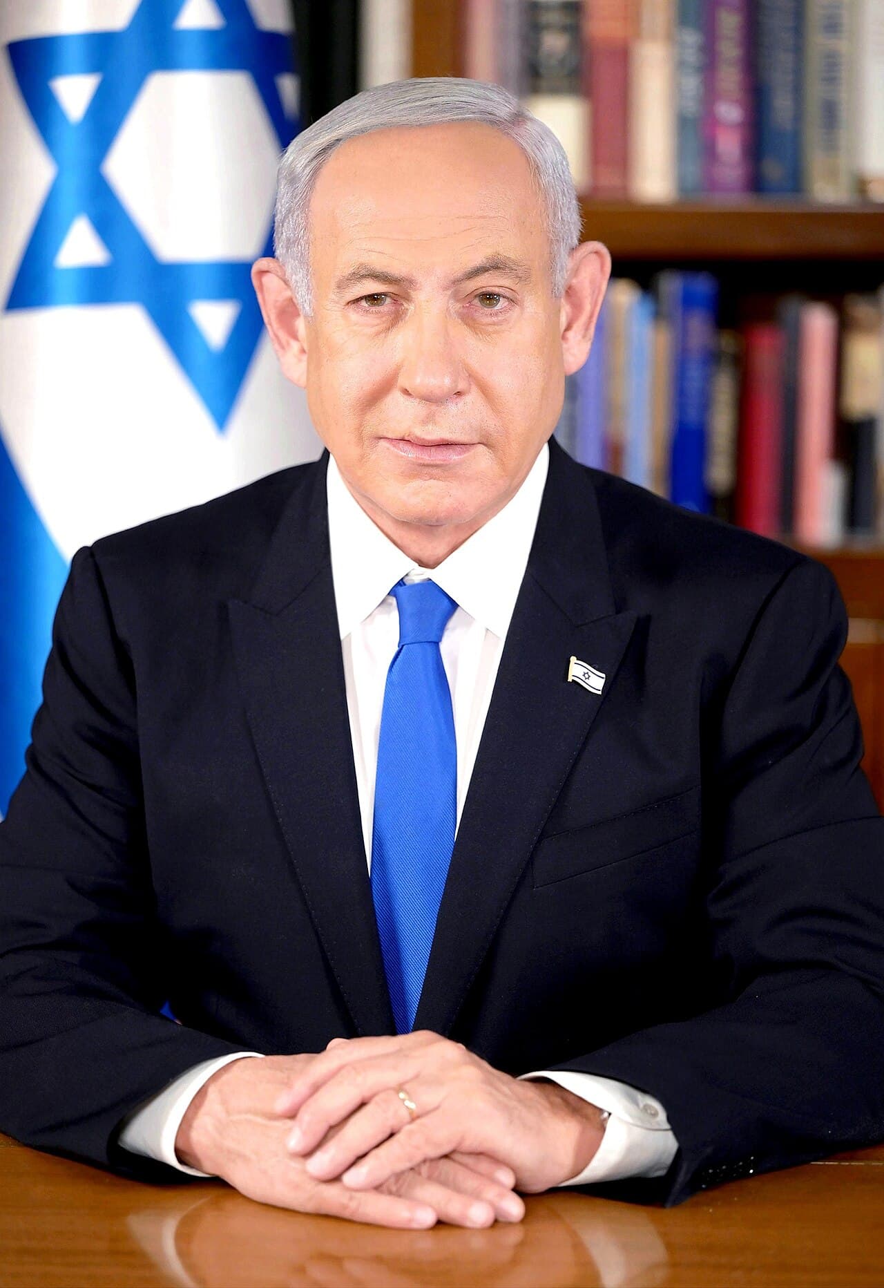 Homme en costume devant un drapeau israélien