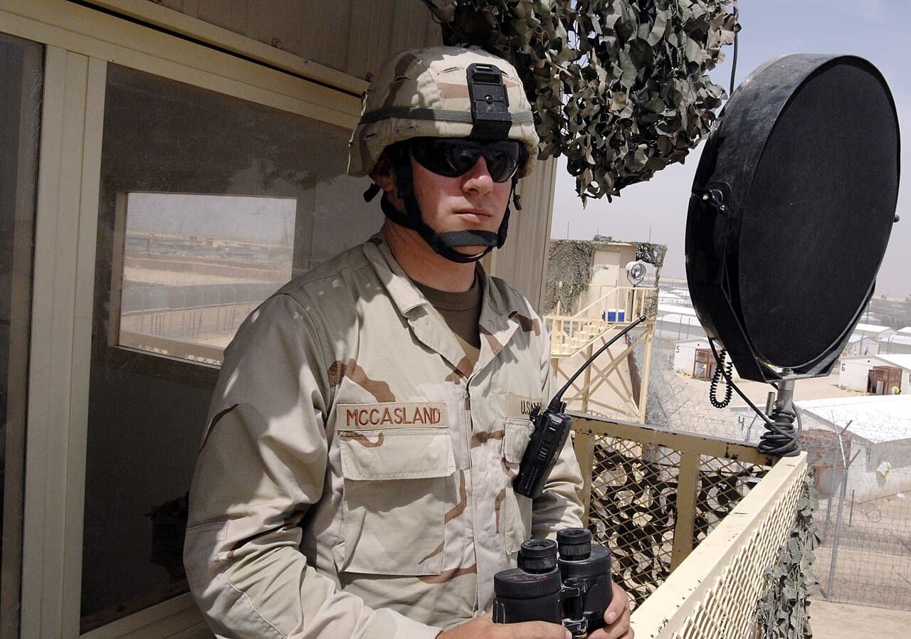 Soldat en uniforme devant une installation militaire